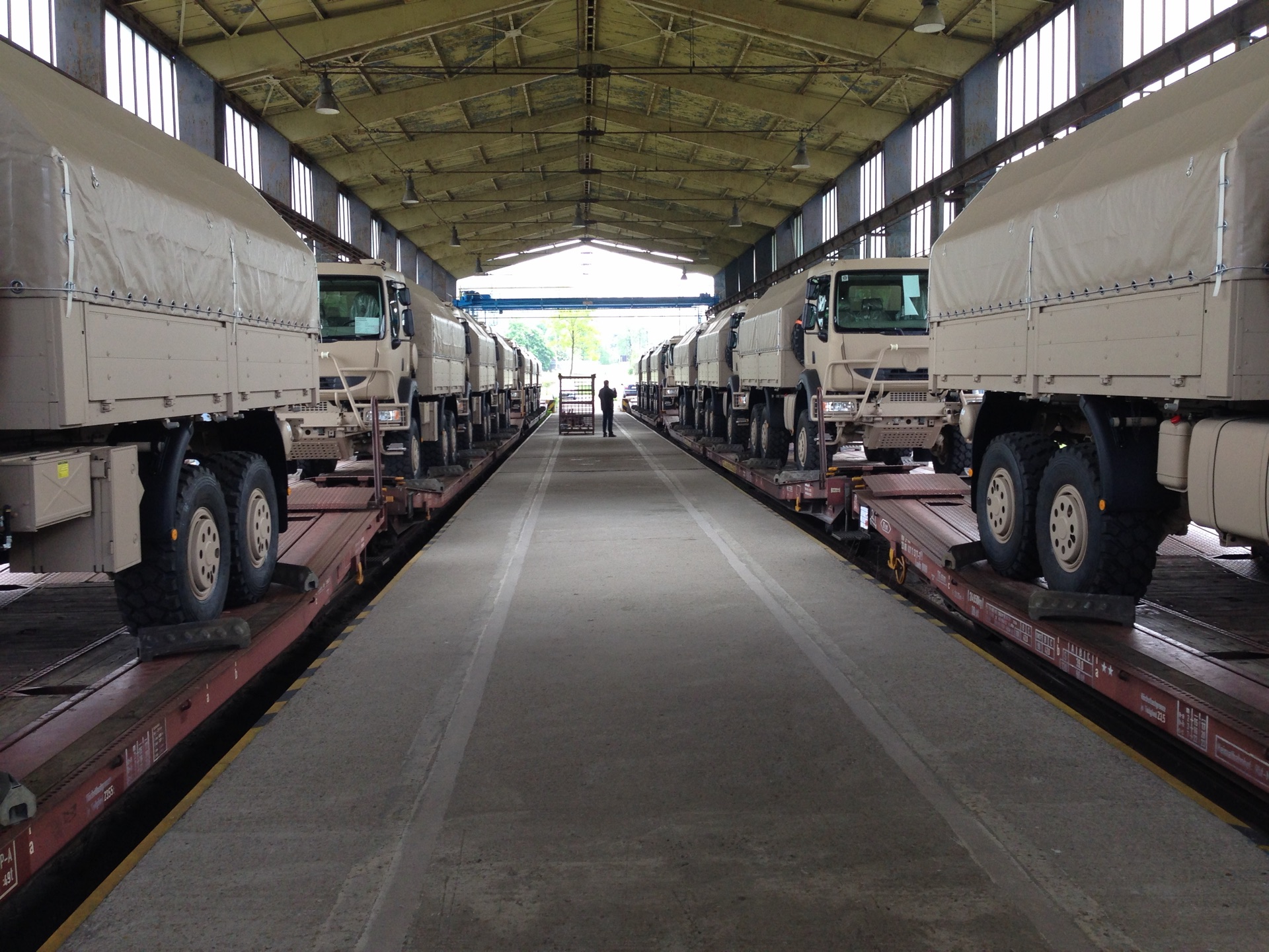 Military vehicles on indoor railway flatcars